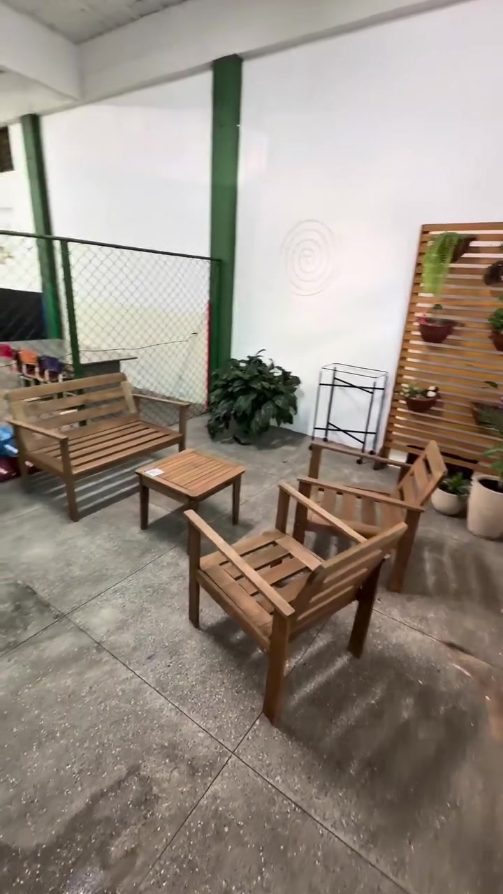 Espaço de convivência com bancos de madeira e jardim vertical na Hora do Recreio