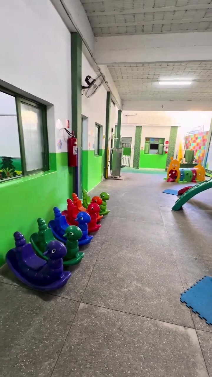 Corredor lúdico com brinquedos e paredes verdes