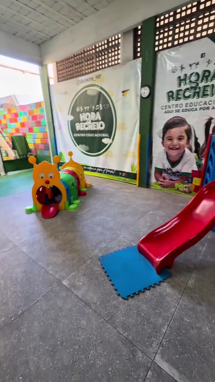 Espaço de recreação da Hora do Recreio com escorregador e a identidade da escola